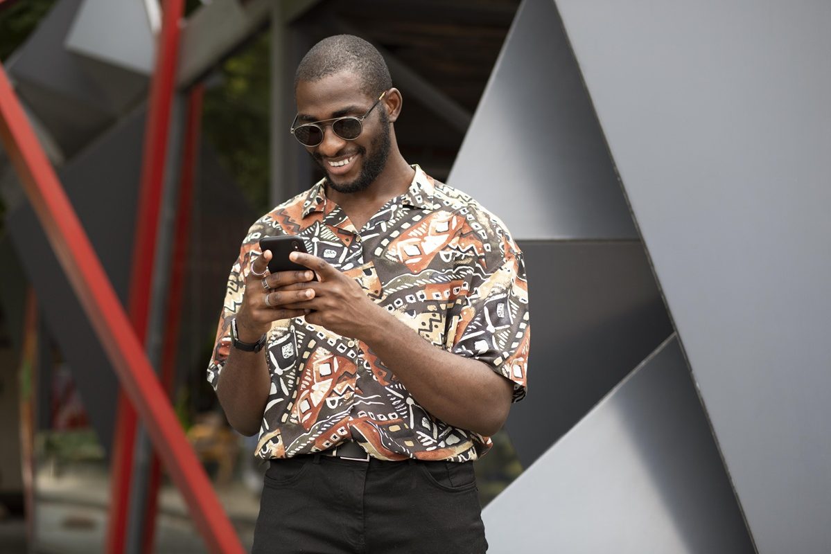 handsome-man-spending-time-outdoors-using-modern-smartphone
